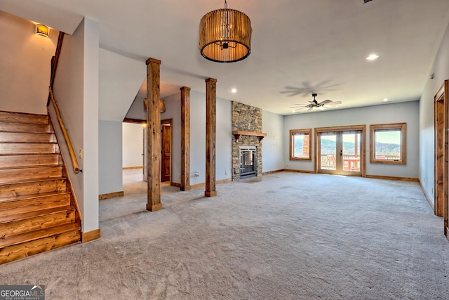 unfurnished living room featuring a fireplace, ceiling fan, light carpet, and french doors