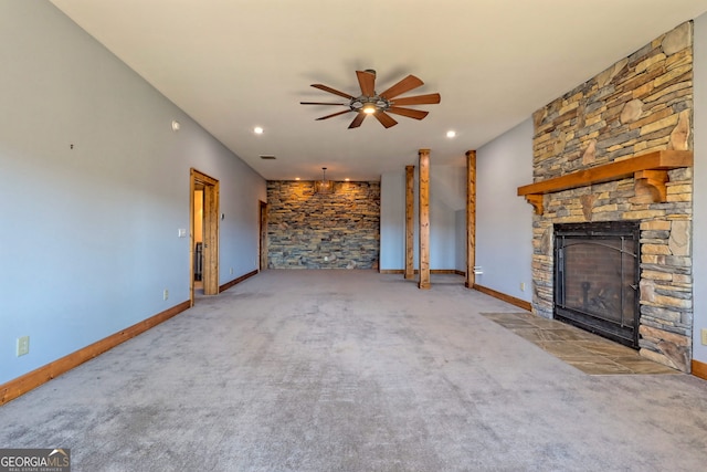 unfurnished living room with a stone fireplace, carpet floors, and ceiling fan