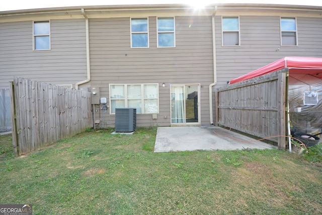 back of property featuring central air condition unit, a yard, and a patio area