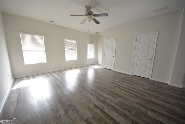 unfurnished room with ceiling fan with notable chandelier and dark hardwood / wood-style floors