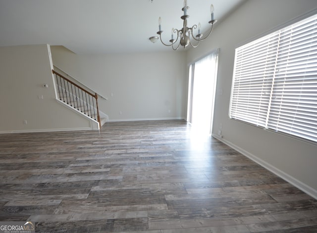 unfurnished room with a chandelier and dark hardwood / wood-style floors