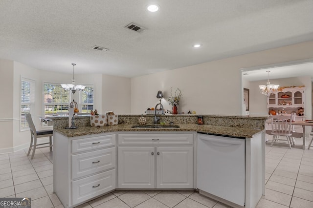 kitchen featuring dishwasher, hanging light fixtures, sink, an island with sink, and white cabinetry