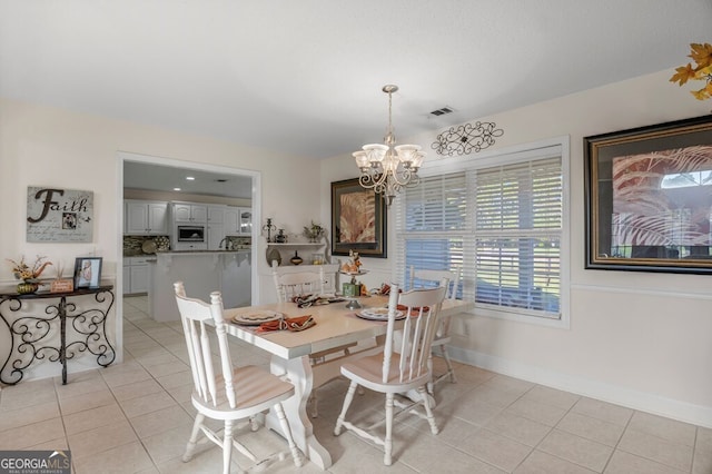 dining room with light tile patterned flooring and a notable chandelier