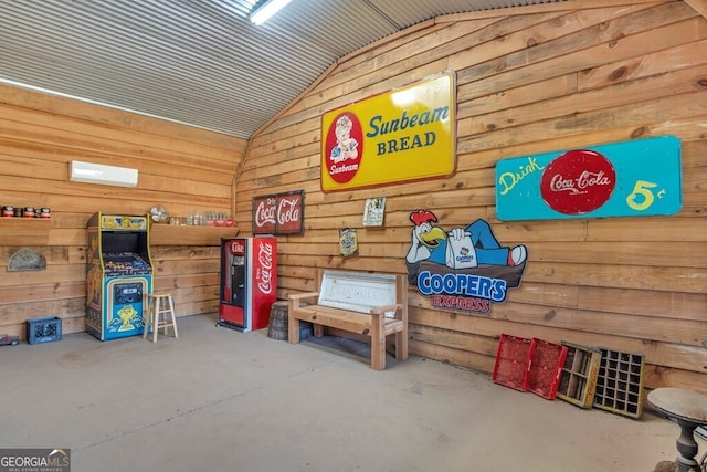 interior space with concrete flooring, lofted ceiling, and wooden walls