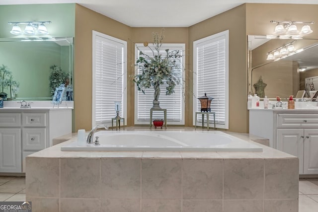 bathroom featuring tile patterned flooring, vanity, and tiled tub