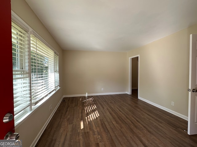 unfurnished room with dark wood-type flooring