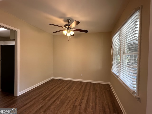 empty room with ceiling fan and dark hardwood / wood-style floors