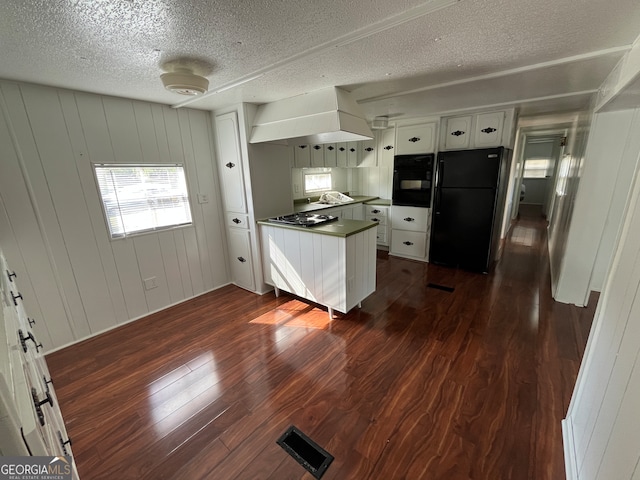 kitchen with dark wood-type flooring, white cabinets, black appliances, a textured ceiling, and sink