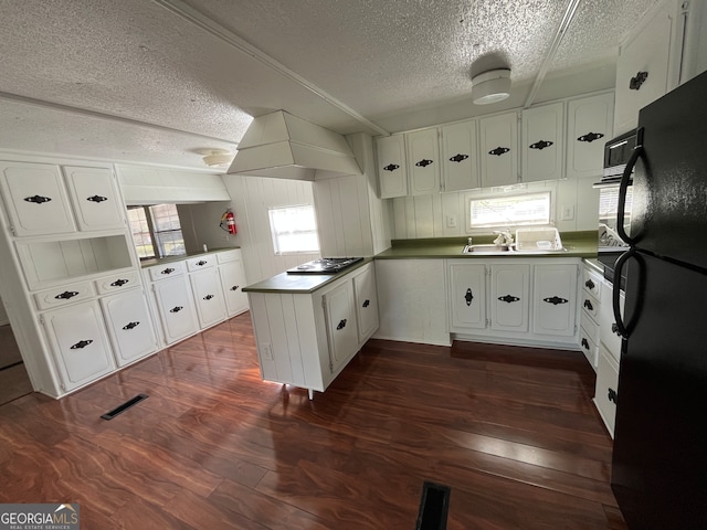 kitchen featuring kitchen peninsula, dark hardwood / wood-style floors, a textured ceiling, white cabinets, and black refrigerator