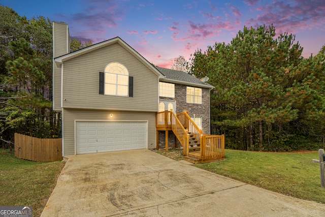 split foyer home with a garage and a lawn