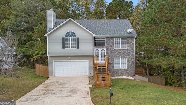 bi-level home featuring a garage, a front yard, and french doors