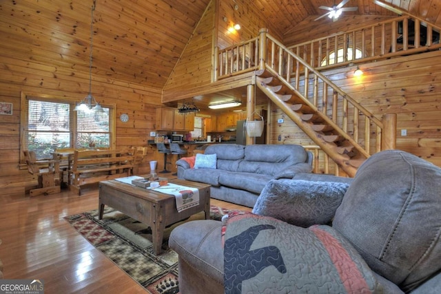 living room with wooden ceiling, light hardwood / wood-style floors, wooden walls, and high vaulted ceiling