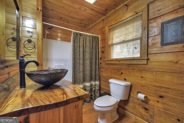 bathroom featuring wood walls, wood ceiling, sink, hardwood / wood-style flooring, and toilet