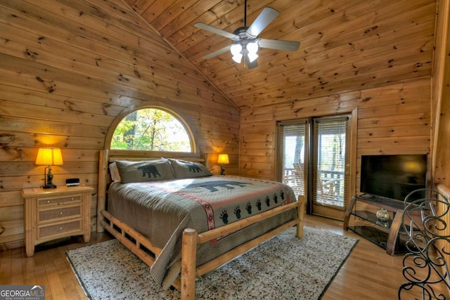 bedroom with light wood-type flooring, wood walls, multiple windows, and ceiling fan