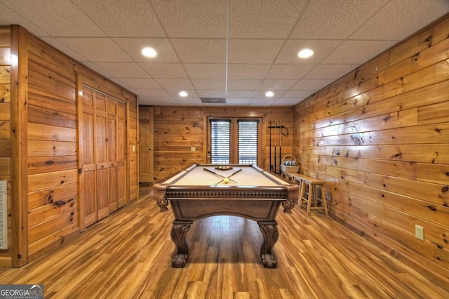 recreation room featuring wooden walls, light hardwood / wood-style flooring, pool table, and a paneled ceiling