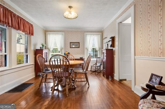 dining space with crown molding, plenty of natural light, and dark hardwood / wood-style flooring