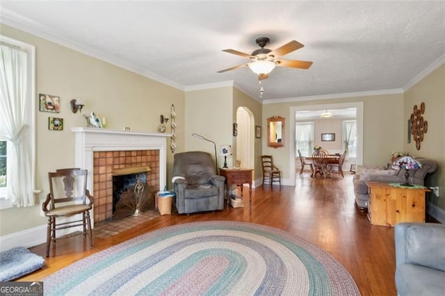 living room with hardwood / wood-style floors, a wealth of natural light, and crown molding