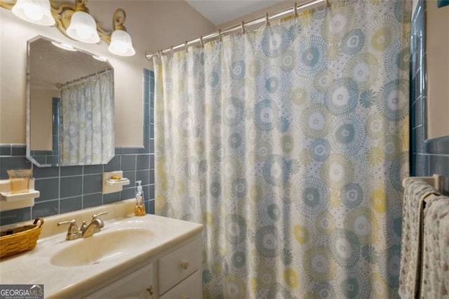 bathroom featuring tile walls, vanity, and a shower with curtain