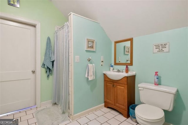 bathroom with tile patterned floors, vanity, toilet, and vaulted ceiling