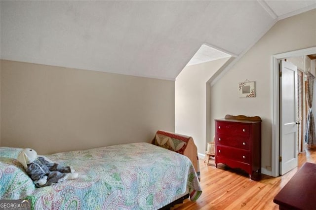 bedroom with hardwood / wood-style floors and lofted ceiling