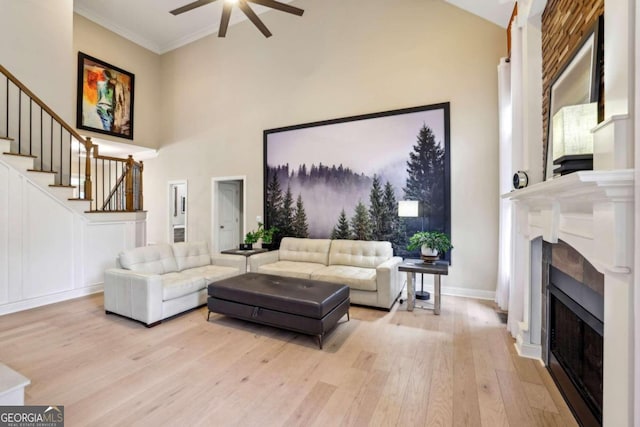 living room featuring ornamental molding, high vaulted ceiling, ceiling fan, and light wood-type flooring