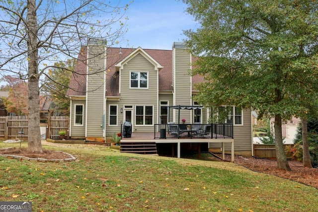 rear view of house featuring a yard and a deck