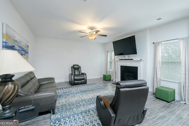 living room with light hardwood / wood-style flooring and ceiling fan