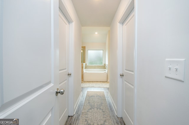 hallway with light hardwood / wood-style floors