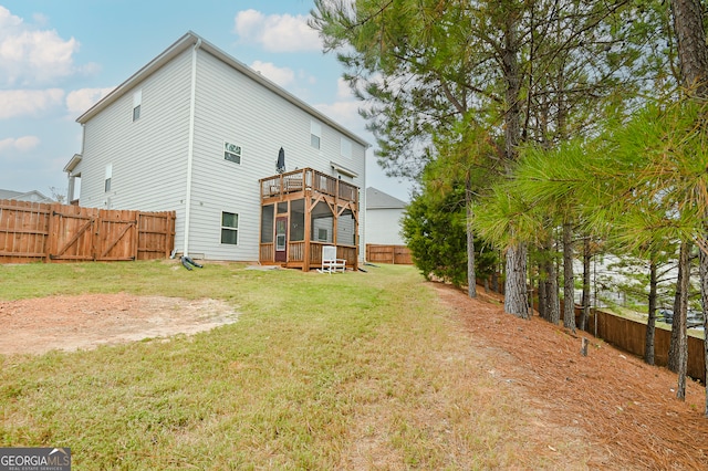 rear view of house with a lawn and a deck