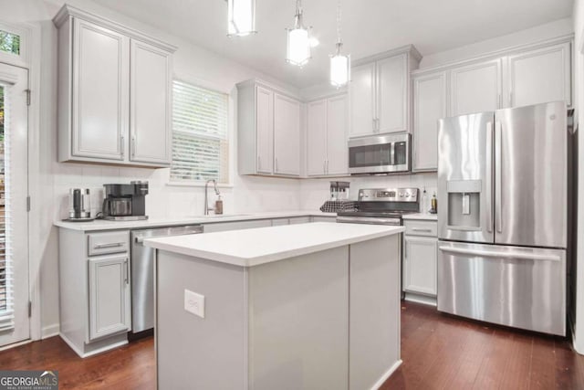 kitchen featuring stainless steel appliances, dark hardwood / wood-style floors, backsplash, and a center island