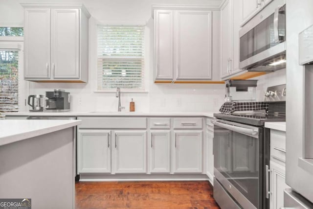 kitchen featuring white cabinetry, decorative backsplash, stainless steel appliances, and dark hardwood / wood-style floors