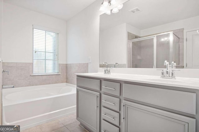 bathroom with independent shower and bath, vanity, and tile patterned flooring