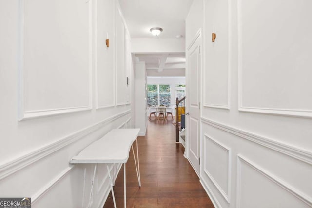 hallway featuring beamed ceiling and dark hardwood / wood-style floors