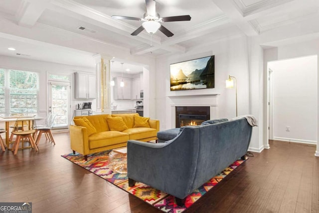 living room featuring ceiling fan, coffered ceiling, dark hardwood / wood-style floors, and crown molding