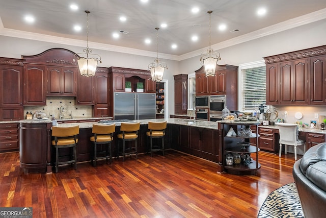 kitchen with stainless steel appliances, dark hardwood / wood-style floors, pendant lighting, and a large island