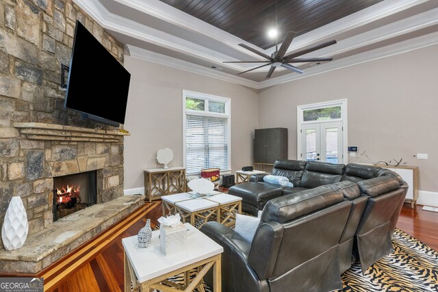 living room with french doors, ornamental molding, a fireplace, dark hardwood / wood-style floors, and ceiling fan