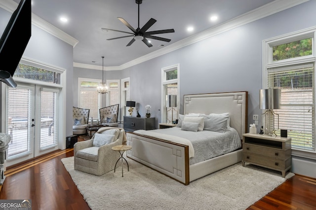 bedroom with hardwood / wood-style flooring, ceiling fan with notable chandelier, and multiple windows