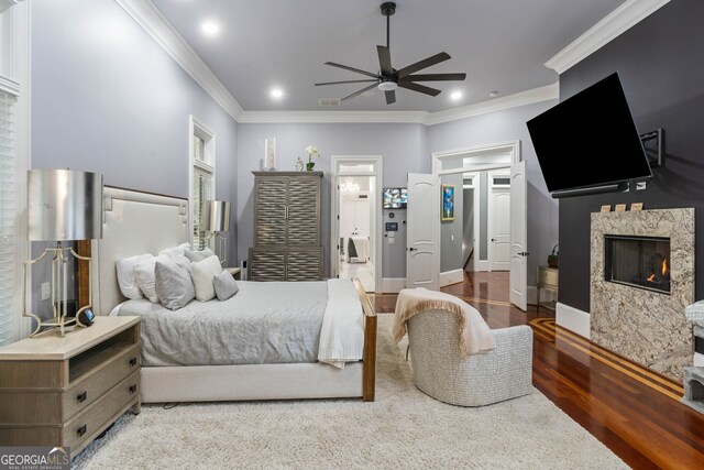 bedroom featuring ensuite bathroom, wood-type flooring, ceiling fan, and crown molding