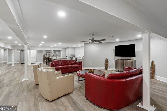 living room featuring ceiling fan and light hardwood / wood-style floors