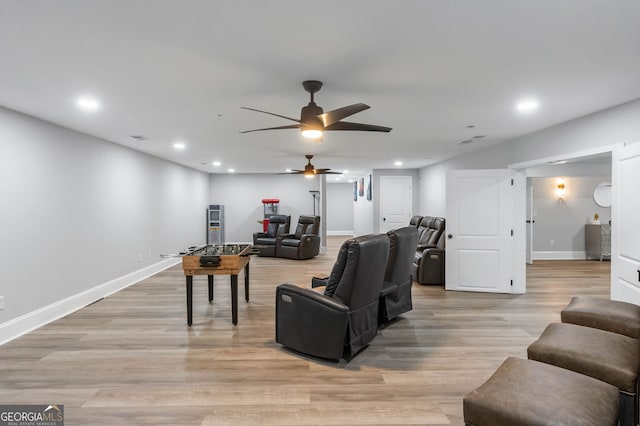 living room with ceiling fan and light hardwood / wood-style flooring