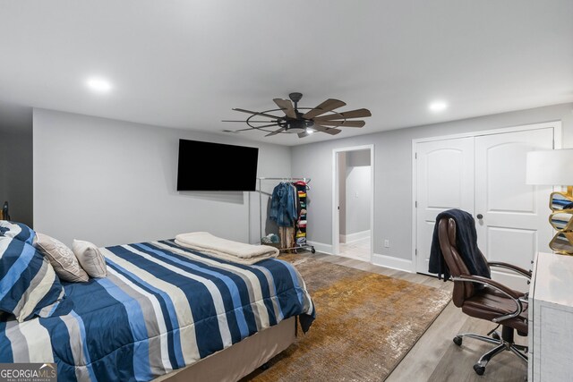 bedroom featuring wood-type flooring, ceiling fan, and a closet