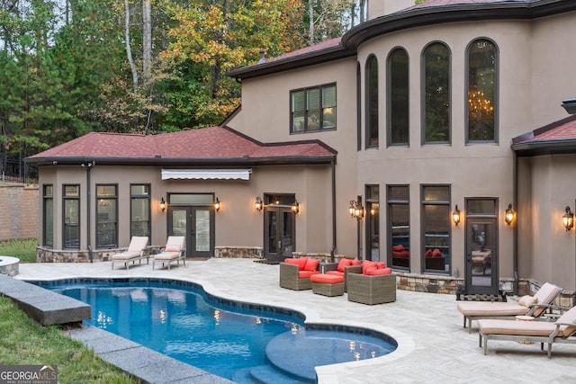 rear view of property featuring french doors, a patio, and an outdoor hangout area