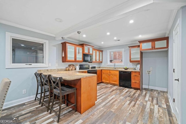 kitchen with black appliances, ornamental molding, hanging light fixtures, hardwood / wood-style floors, and kitchen peninsula