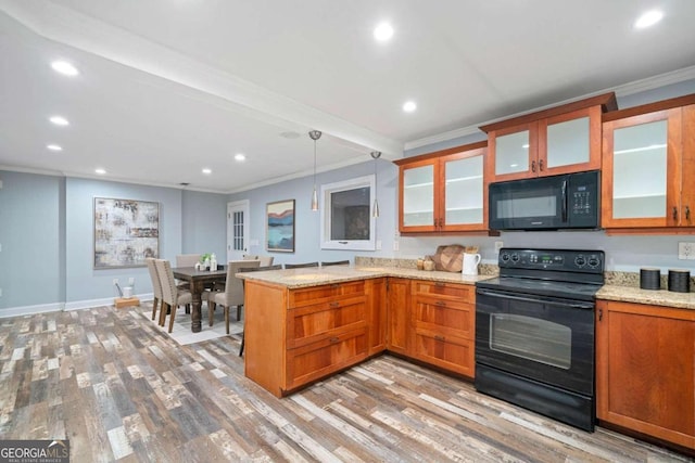 kitchen with light hardwood / wood-style floors, kitchen peninsula, black appliances, ornamental molding, and pendant lighting