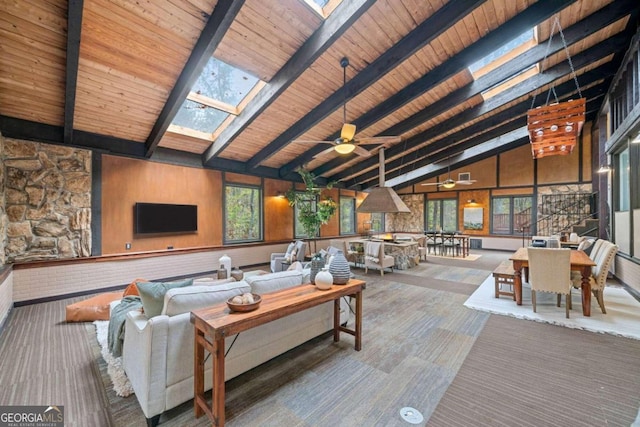 living room featuring high vaulted ceiling, a skylight, wood ceiling, and a healthy amount of sunlight