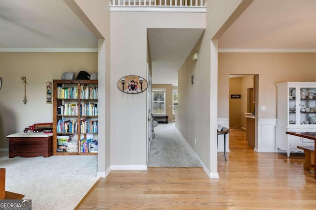 foyer with light wood-type flooring and crown molding