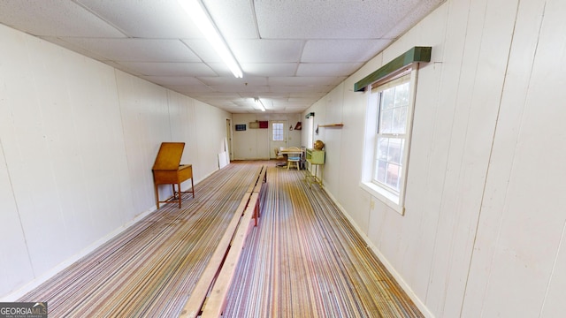 game room with wood walls and a paneled ceiling