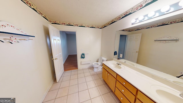 bathroom featuring tile patterned flooring, vanity, a textured ceiling, and toilet