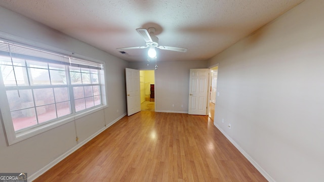 interior space with ceiling fan, a textured ceiling, and light hardwood / wood-style flooring