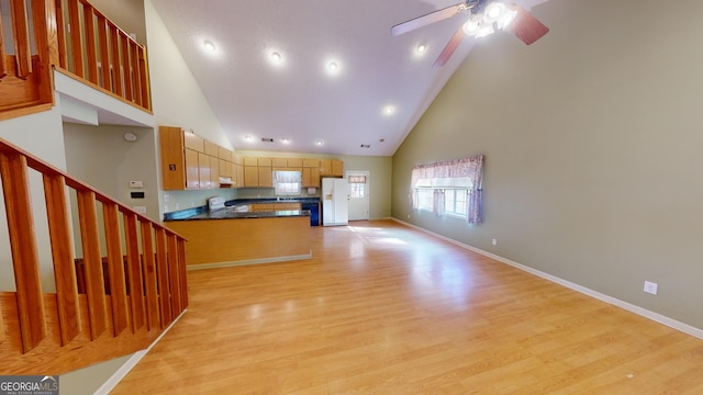 kitchen with kitchen peninsula, high vaulted ceiling, light hardwood / wood-style floors, white appliances, and ceiling fan